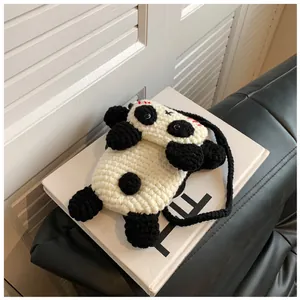 Close-up of handmade crochet panda bag showing detailed knit texture and woven strap