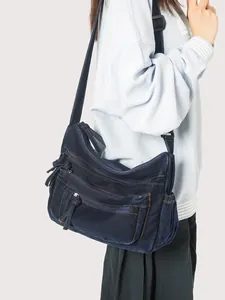 Deep blue denim crossbody bag with multiple zippers and adjustable strap for women