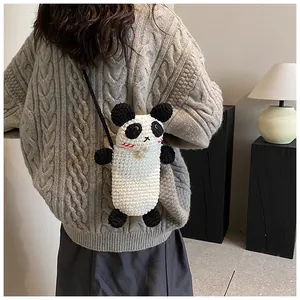 Macro detail of hand-knitted panda crossbody bag showing texture and 3D ears