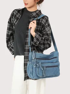 Retro denim crossbody bag with multiple pockets and adjustable strap shown on model