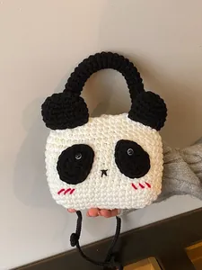 Handmade crochet panda shoulder bag with black strap and soft knit texture for women