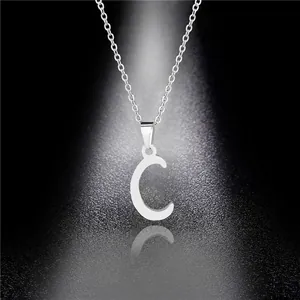 Macro shot of polished stainless steel letter C pendant with silver mirror finish