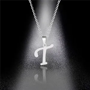 Close-up of polished silver stainless steel T-letter pendant necklace on black background
