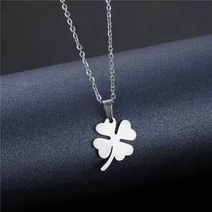 Polished stainless steel four-leaf clover pendant necklace for women on a blue pedestal