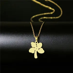 Minimalist gold stainless steel four leaf clover necklace on a black textured background