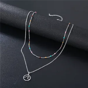 Double-layer stainless steel wave pendant necklace with colorful beads on a black stand