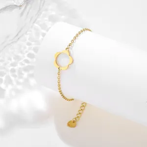 Detail of gold hollow flower bracelet with heart tag and S. Steel engraving