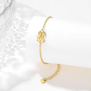 Detail of golden stainless steel bracelet with a cute puppy pendant and heart charm end