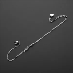 Bracelet aile d'ange en acier argenté avec breloque cœur sur fond gris mat