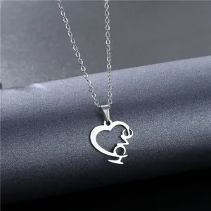 Polished silver stainless steel heart necklace with LOVE engraving hanging on a display stand
