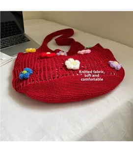 Close-up of red knitted tote bag showing hollow crochet mesh and 3D floral accents