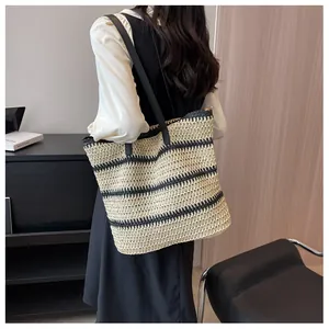 Detail of bohemian striped straw tote bag with black handles in a modern home setting