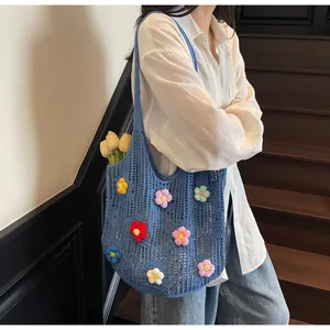 Close-up of blue crochet tote bag with colorful 3D flowers on model with wooden stairs