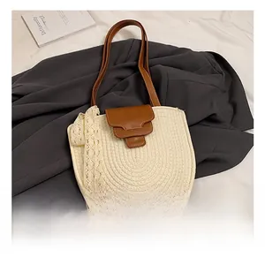 Détails du sac en paille tissée avec bandoulière en cuir marron et ruban en dentelle