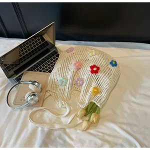 Detailed close-up of a white crochet tote bag with colorful 3D knitted flower accents
