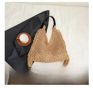 Detailed texture of hand-woven bohemian tote bag with fringe and black leather strap