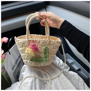 Detailed texture of woven bag with crochet tulips and elegant pearl chain strap