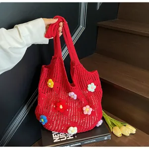 Detail of red crochet tote bag featuring colorful 3D knitted flower decorations
