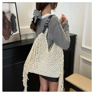 Detail of cream crochet bag with fringe and adjustable black leather shoulder strap