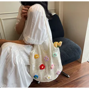 Detailed knit of beige crochet tote bag with colorful 3D floral accents and openwork