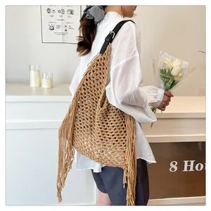 Detail of hand-woven hollow knit tote bag with long side tassels and black leather strap