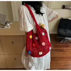 Detail of red crochet tote bag with colorful 3D floral accents and hollow knit patterns