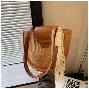 Détail du sac bandoulière en coton tissé avec rabat en cuir brun et ruban de dentelle