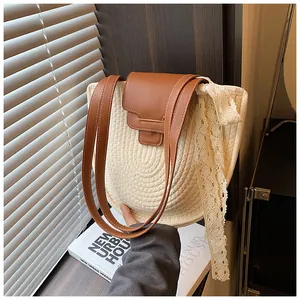 Détail du sac bandoulière tissé avec rabat en cuir marron et ruban en dentelle fine