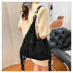 Detailed view of black crochet tote bag featuring long tassels and premium leather strap