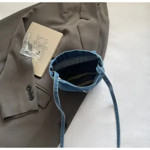 Detail of blue denim crossbody bag interior and stitching against retro aesthetic background