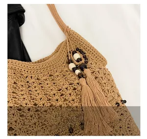 Detail of woven cotton tote bag with intricate hollow patterns and wooden bead tassels