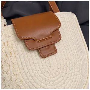 Gros plan du sac en coton tissé avec bordure en dentelle blanche et rabat en cuir brun