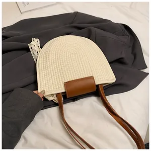 Détail du sac bandoulière tissé avec bordure en dentelle blanche et sangle marron