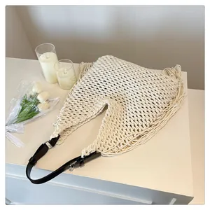 Detail of hollow woven cotton bag showing ivory mesh texture and long tassel fringe