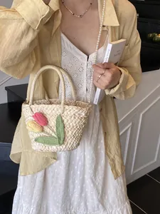 Chic straw handbag with crochet flowers and pearl strap for beach vacation styles