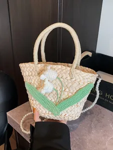 Woven straw handbag with white crochet flowers and a pearl bead chain strap