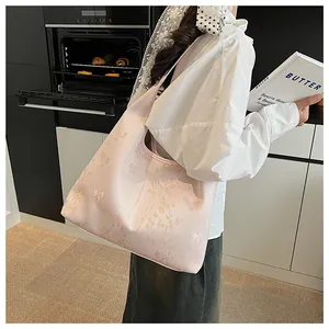 Detailed close-up of pink tote bag with gold butterfly embroidery and bamboo patterns