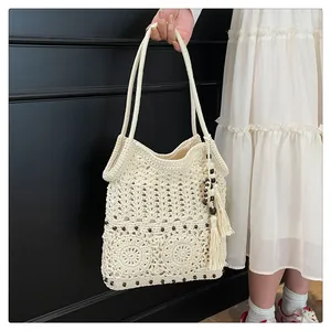 Detail of bohemian cotton crochet shoulder bag with dark wood beads and side tassels