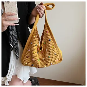Detail of yellow knit shoulder bag featuring colorful pearl hollow-out crochet texture