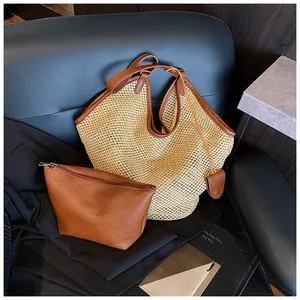 Close-up of woven straw tote bag with brown leather trim and matching inner pouch