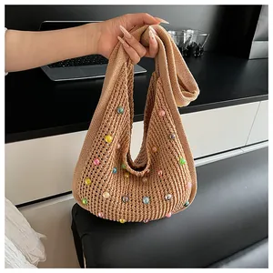 Detail of khaki knit shoulder bag with multicolored beads and hollow crochet texture