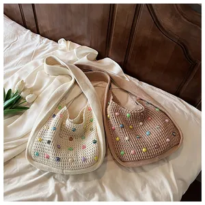 Detailed texture of hollow knit bags with pearl beads in cream and khaki colors