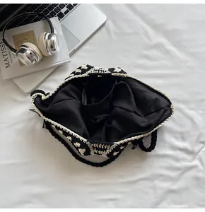 Macro view of hand-crocheted black and white tote bag with fabric lining and interior pocket