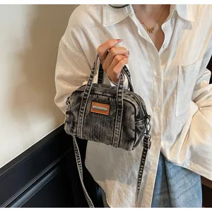 Close-up of retro washed denim bowling bag with leather label and metallic brand tag
