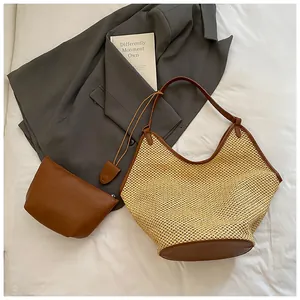 Detail of woven straw tote bag and brown leather pouch set for beach or work