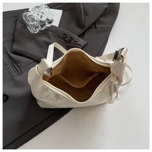 Detail view of floral embroidered handbag showing inner lining and zipper pocket