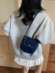 Retro denim crossbody bag with contrast stitching and silver snap closure on the flap