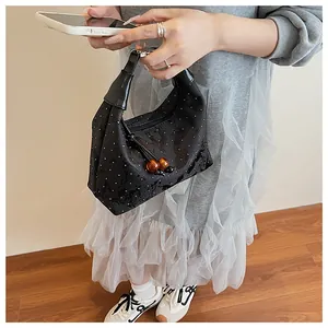 Detail of black polka dot handbag featuring amber bead charms and nylon texture