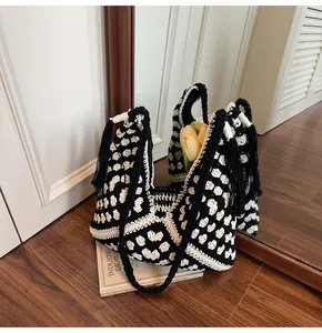 Detail of bohemian black and white crochet tote bag with fringe and floral interior