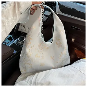 Detail of blue tote bag with embroidered butterflies and bamboo shadows in car interior